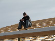 Laura's on the roof waiting for me to pass her a piece of siding