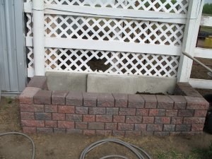 Putting concrete plates at the back of the garden to keep in the dirt